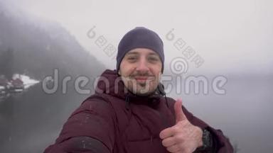 冬天，<strong>人们</strong>在阿布哈兹的里萨湖上<strong>自拍</strong>并展示拇指。